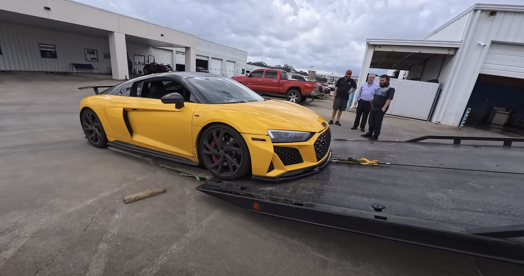 Secure long-distance vehicle transport service Yellow luxury sports car being loaded onto professional flatbed trailer for long-distance transport