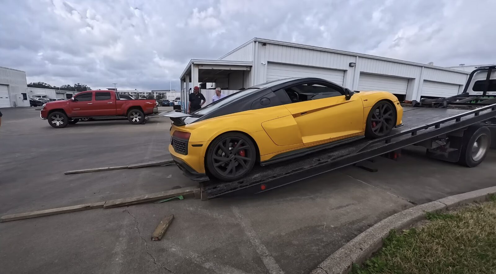 Modern flatbed tow truck transporting a luxury sports car safely