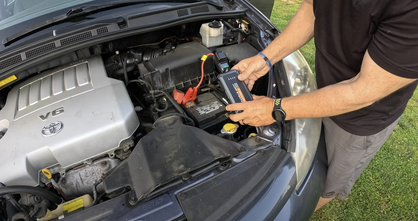 Professional towing service technician jump-starting a car battery in Bowie, MD