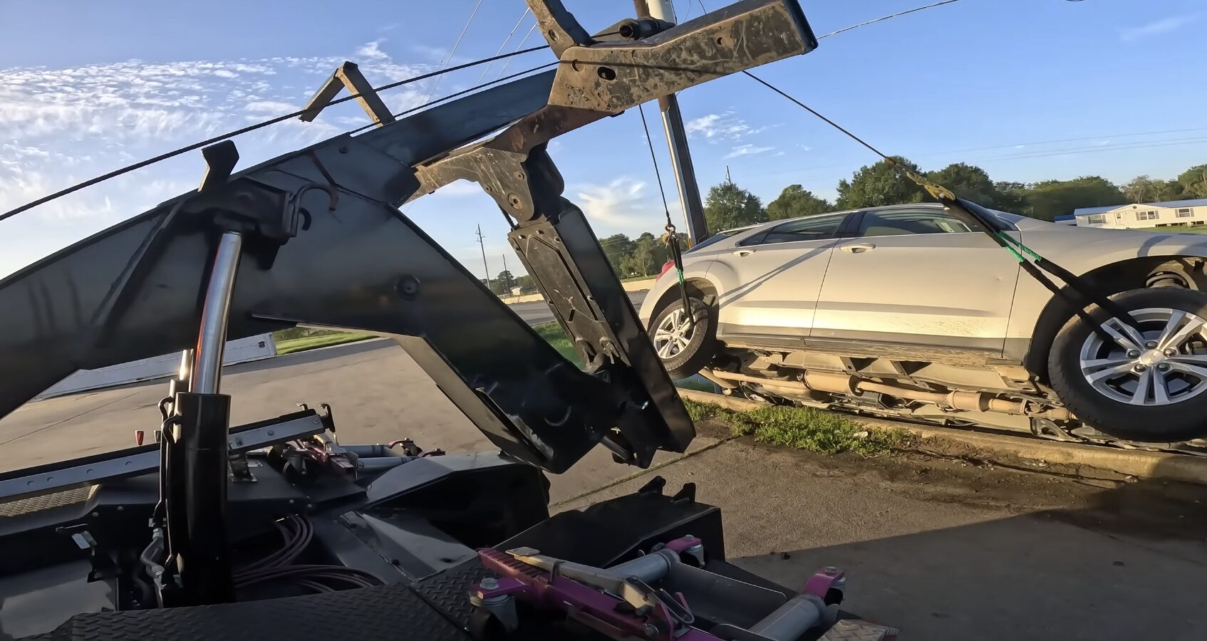 Safe and secure car towing process Car being secured on flatbed tow truck showing professional towing equipment and safety measures